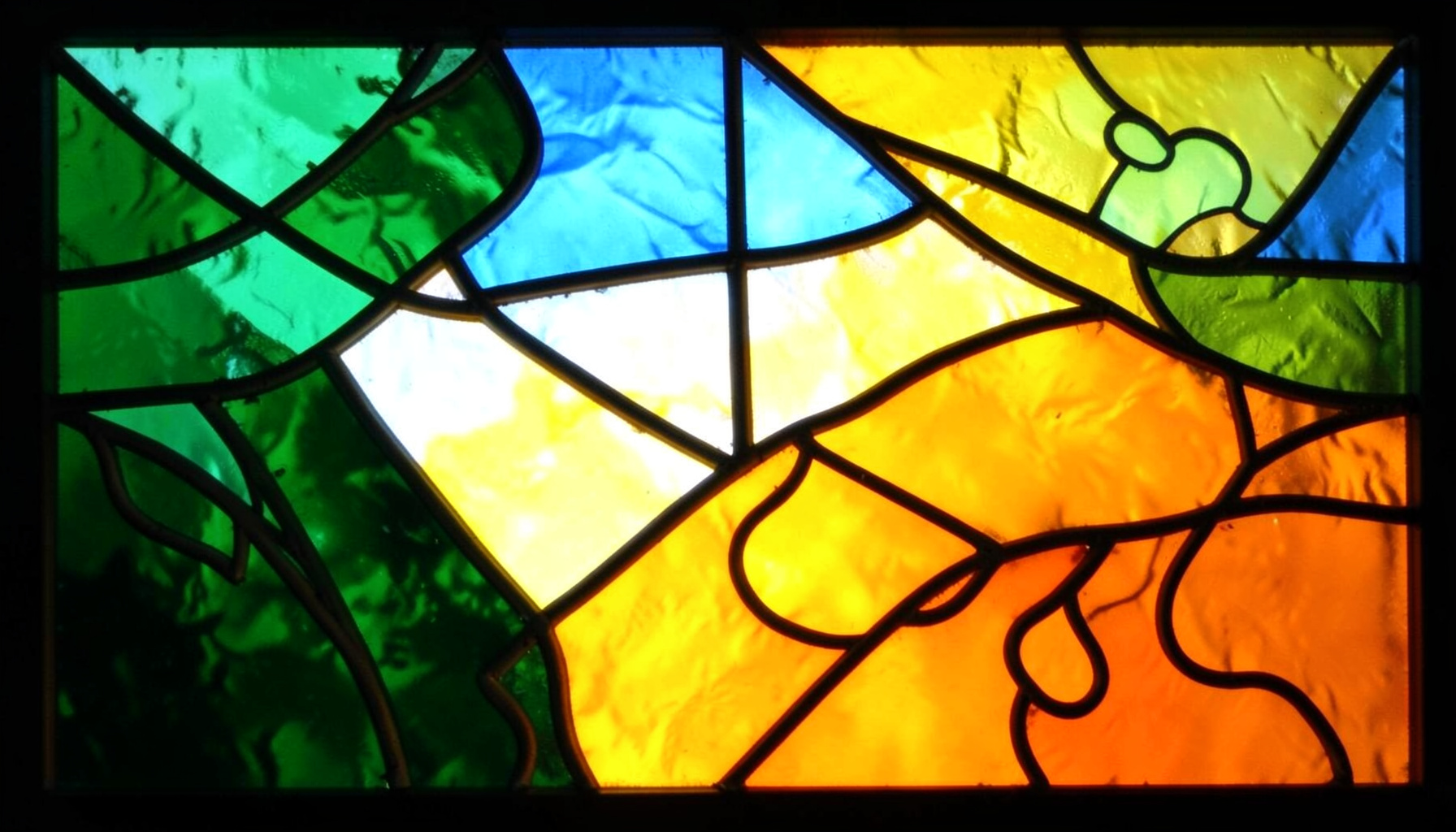 A stained-glass composition with bold leaded segments in forest green, sky blue, and sunny yellow, evoking travel and puzzle adventure